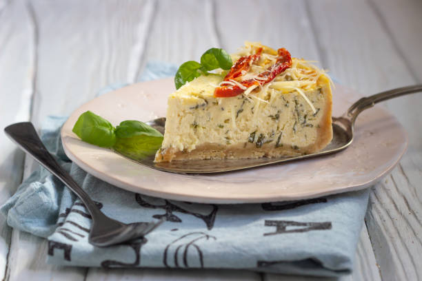stuk hartige cheesecake met kruiden verfraaide zongedroogde tomaten, kaas en verse basilicum. - hartig voedsel stockfoto's en -beelden