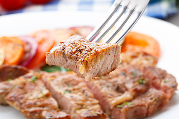 Piece of steak on fork stock photo