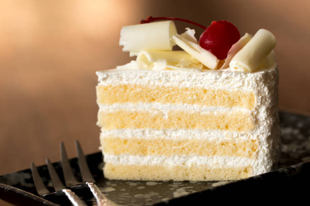 stück weißer kuchen mit vanillefrosting und kirschgelee, gekrönt mit weißkäse. - kuchenstück stock-fotos und bilder