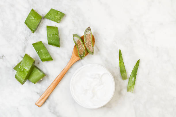 Pieces of aloe vera leaf with a moisturizer cream pot Pieces of aloe vera leaf with a moisturizer cream pot on a marble table aloe stock pictures, royalty-free photos & images