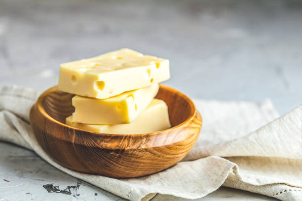 Pieces of cheese in wooden plate stock photo