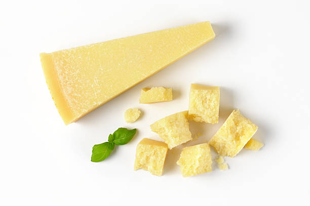pieces of parmesan cheese wedge and pieces of fresh parmesan cheese on white background parmesan cheese stock pictures, royalty-free photos & images