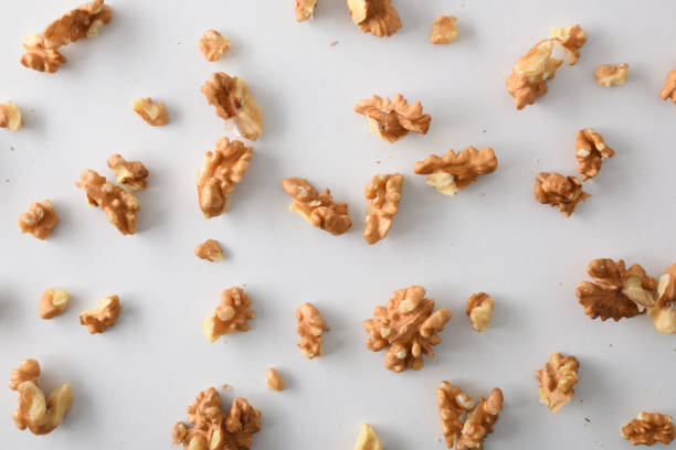 pieces of walnuts on white table top stock photo