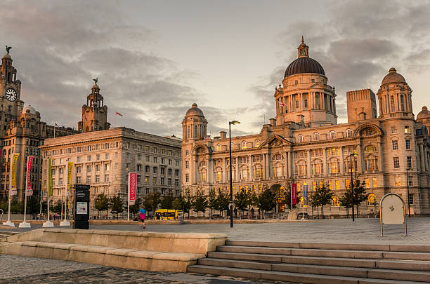 Pier Head at Sunset, Liverpool Liverpool, UK - October 1, 2014: Port of Liverpool Building and Cunard Building at Sunset. Located on the Pier Head, an Unesco World Heritage Site, they are two of the famous Three Graces. Collectively, along with The Royal Liverpool Building, they are the instantly recognisable image of Liverpool. Together with the open space of the Pier Head, they comprise one of the most impressive waterfronts in the world. cunard building liverpool stock pictures, royalty-free photos & images