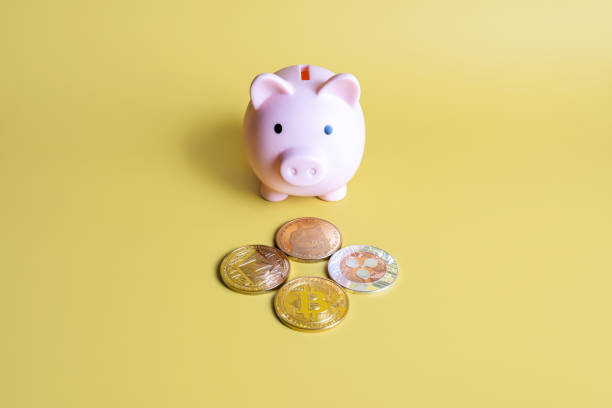 Piggy bank and Bitcoin, XRP, Dogecoin, Ethereum cryptocurrency coins on yellow background Piggy bank next to popular crypto coins on yellow background. Bitcoin, Ripple XRP, Dogecoin and Ethereum.  With Ethereum  stock pictures, royalty-free photos & images