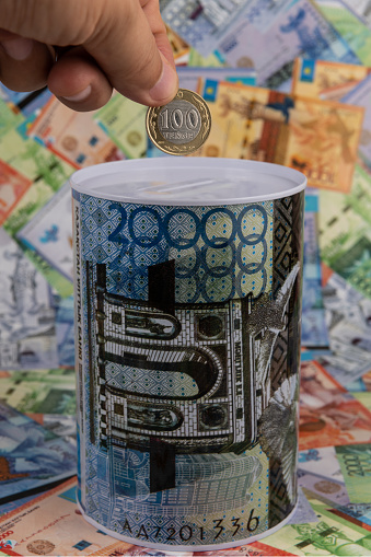 Piggy bank with the image of a banknote of 20,000 Kazakhstani tenge against the background of other Kazakhstani banknotes