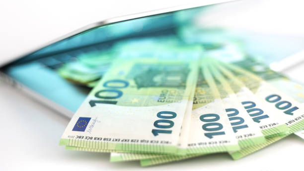 Pile of 100 euro banknotes on the laptop stock photo