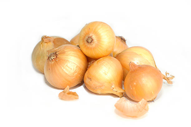 Pile of brown onions on white background stock photo