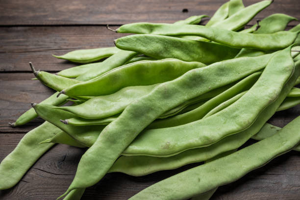 A pile of fresh green beans on table. Green runner beans. Top view A pile of fresh green beans on table. Green runner beans. Top view runner bean stock pictures, royalty-free photos & images