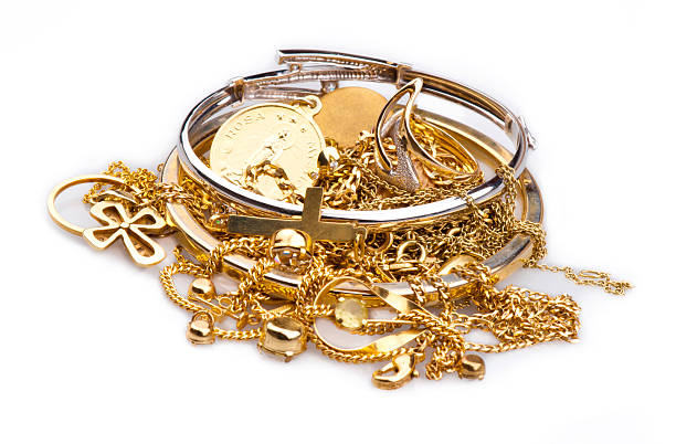 A pile of gold and silver scrap jewelry on white Pile of Gold Jewelry on a white background gold jewelry stock pictures, royalty-free photos & images