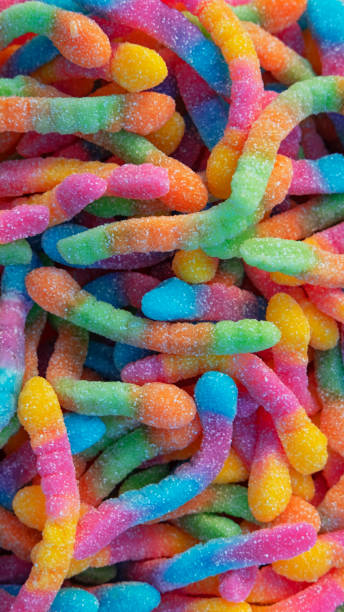 Pile of neon sugary gummy worms or  chewy sour crawlers background stock photo
