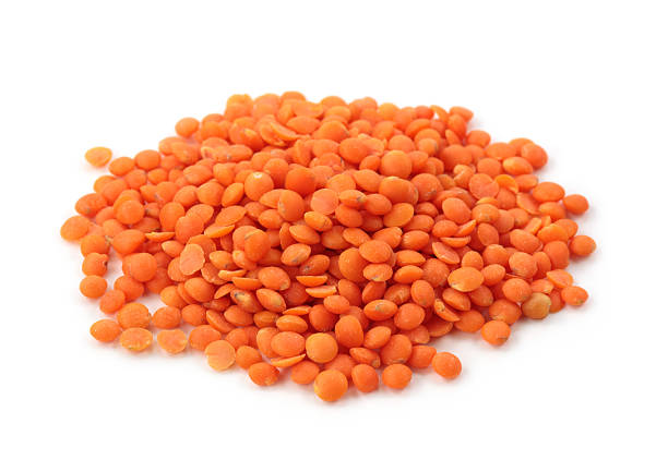 Pile of orange lentils on white background stock photo