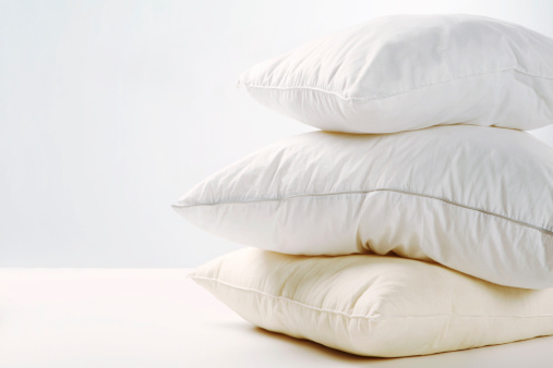 A pile of three white pillows. White background.
