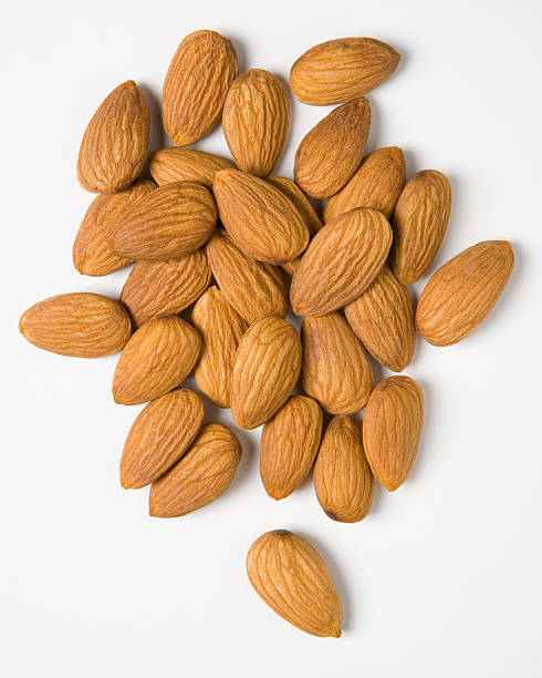A pile of raw almonds on a white background stock photo