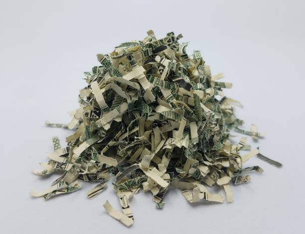 pile of shredded United States money on white background stock photo
