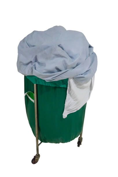 een stapel van tweedehands kleding in ziekenhuis roerende trolley met groene tas voor wasgoed. - waste disposal stockfoto's en -beelden