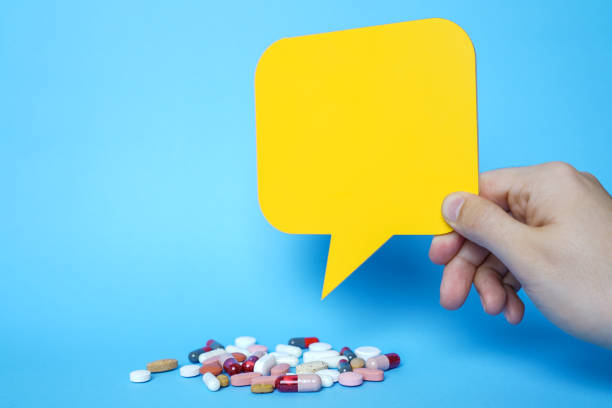 Pills and copy space with yellow speech bubbles on blue background. stock photo