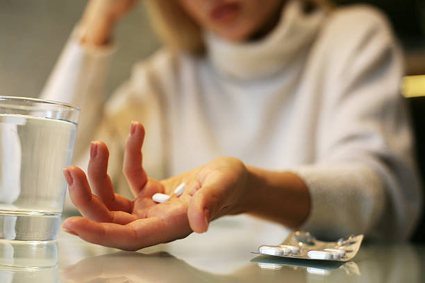 pills in woman hands. - pijnstiller stockfoto's en -beelden