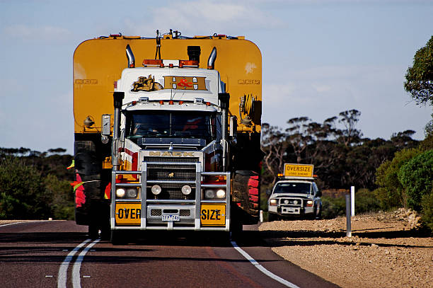 Pilot car following a huge Australian truck stock photo