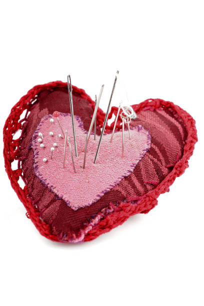 Pink and red heart shape with needles and thread stock photo