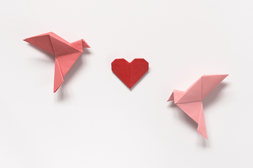 Pink Birds and Red Heart of origami on white background. Gift card for Valentine's Day.