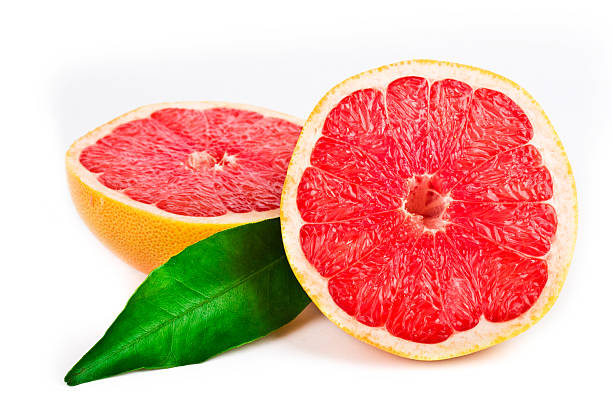 Pink grapefruit cut in half with a green leaf stock photo