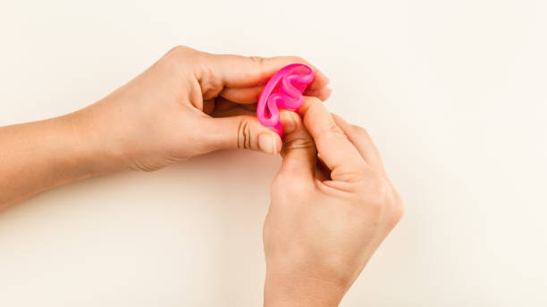 Pink Menstrual Cup folded with a E-Fold Method stock photo
