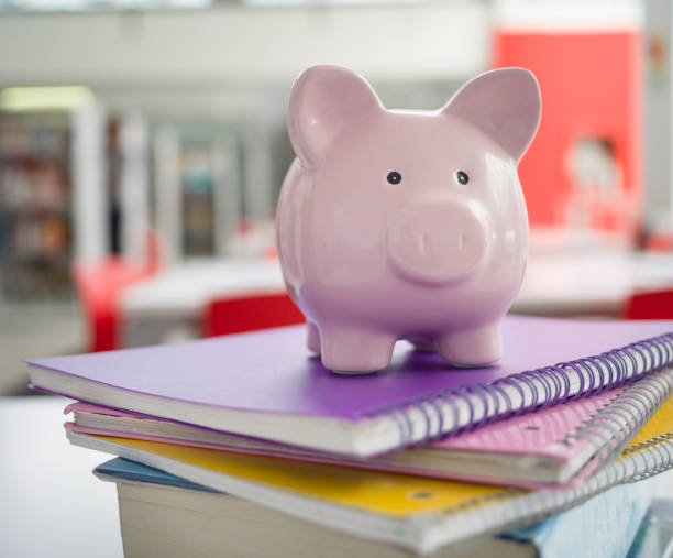 Pink piggy bank on top notebooks - Student loans Pink piggy bank on top notebooks - Student loans student loan stock pictures, royalty-free photos & images