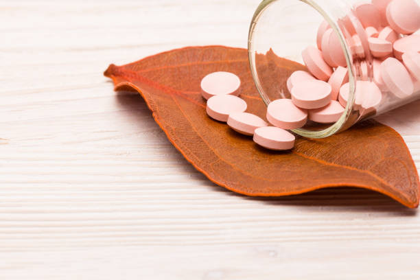 Pink pills with orange leaf stock photo