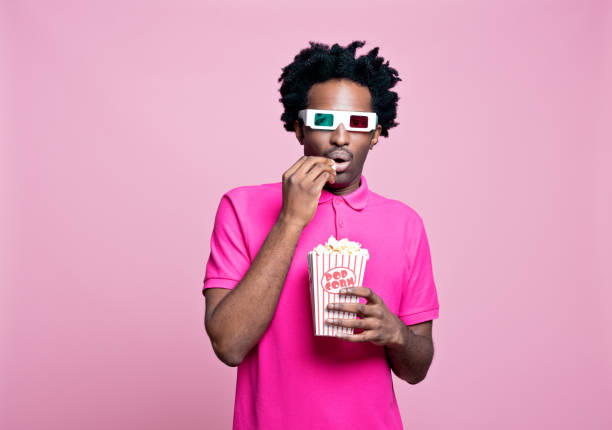 verticale rose de jeune homme inquiété utilisant des glaces 3d mangeant le maïs éclaté - 3d man photos et images de collection