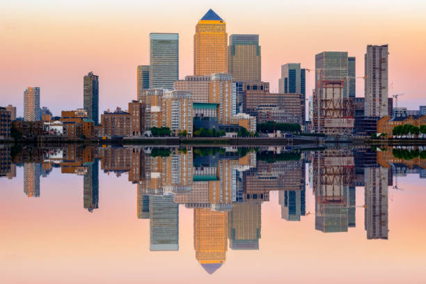 Pink sunset at Canary Wharf in London Pink sunset at Canary Wharf and its reflection from river Thames in London canary wharf stock pictures, royalty-free photos & images