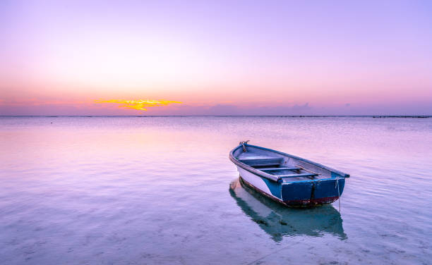 Pink sunset boat in the sea stock photo