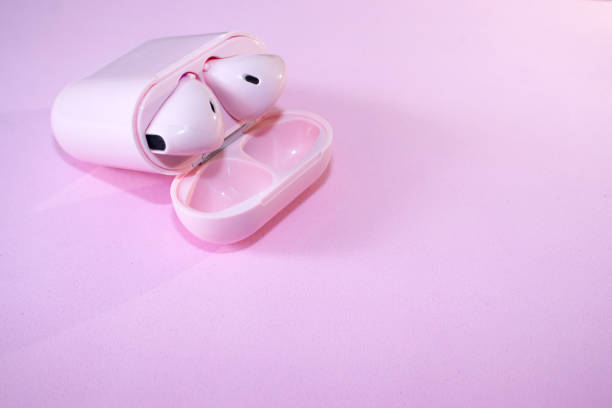 Pink wireless headphones in a case on pink background. The concept of technology and progress. Pink wireless headphones in a case on pink background. The concept of technology and progress. aqua menthe photos stock pictures, royalty-free photos & images