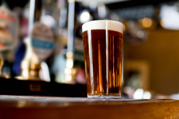 Pint of real ale on the bar in a traditional English pub Pint of real ale on the bar in a traditional English pub in the United Kingdom pint glass stock pictures, royalty-free photos & images