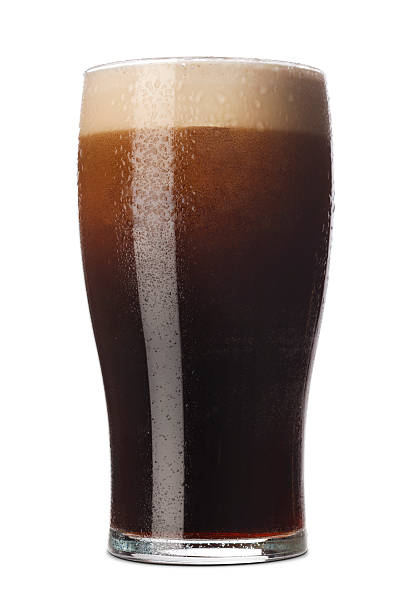 Pint of Stout Freshly pulled pint of Stout with its frothy head in a traditional pint glass. Isolated on white with a small shadow pint glass stock pictures, royalty-free photos & images