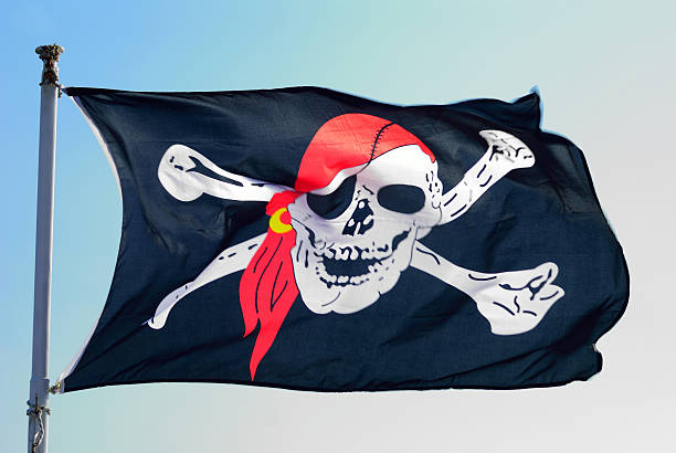 Pirate flag fluttering ominously on the wind stock photo