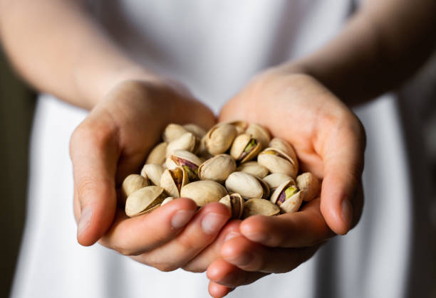 Pistachio in a womans hands. Pistachio nuts is a healthy vegetarian protein and nutritious food. Nuts in a humans hand. Pistachio in a womans hands. Pistachio nuts is a healthy vegetarian protein and nutritious food. Nuts in a humans hand pistachio stock pictures, royalty-free photos & images