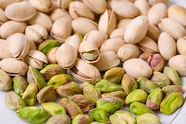 Pistachios Shelled and unshelled roasted pistachios. pistachio stock pictures, royalty-free photos & images