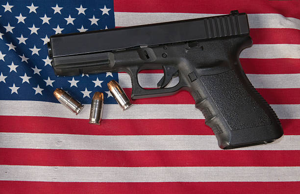 Pistol, ammo and the flag. Pistol and ammunition on top of an American flag. nra stock pictures, royalty-free photos & images