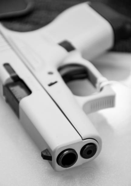 Pistol laying on Counter at a Gun store in Texas after another school shooting black and white Pistol laying on Counter at a Gun store in Texas after another school shooting black and white looking down the barrel of a gun texas school shooting stock pictures, royalty-free photos & images