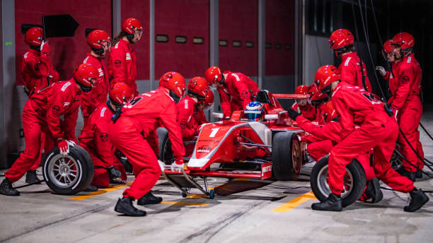Pit stop team working on a red formula race car stock photo