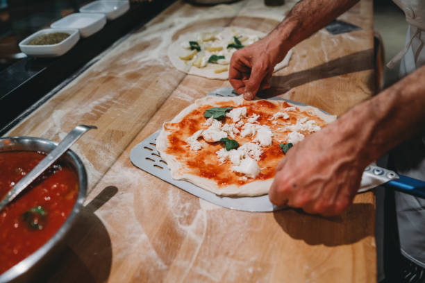 pizza chef bereidt een pizza in het restaurant - napoli stockfoto's en -beelden