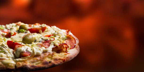 Pizza isolated in an out of focus wooden fire background stock photo