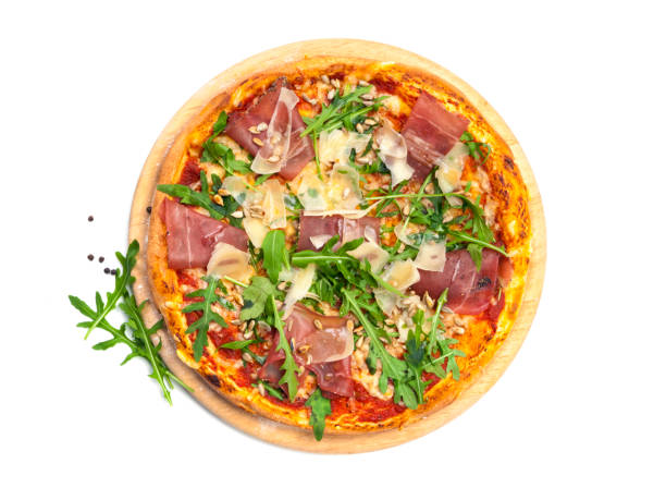 Pizza with dry cured ham, parmesan cheese, rocket and pine nuts on wooden platter, isolated on white stock photo