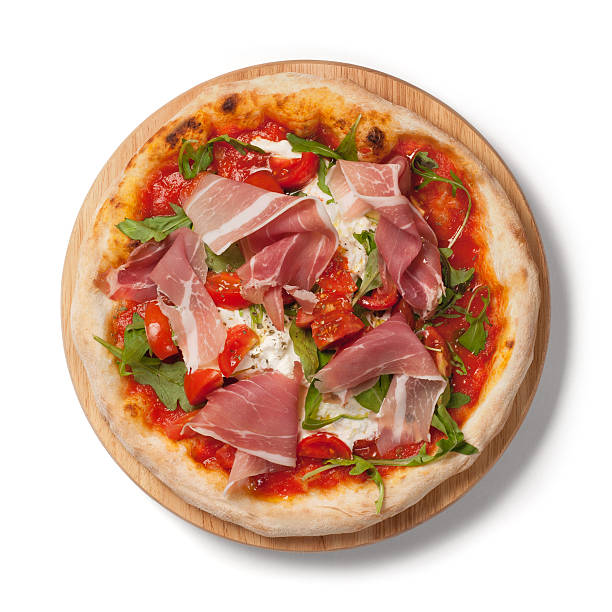 Pizza with  fresh tomatoes, arugula, Parma ham on wodden plate stock photo