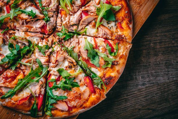 pizza con mozzarella, pesce salmone, salsa di pomodoro, pepe. pizza italiana su tavolo in legno - tonno frutto di mare foto e immagini stock
