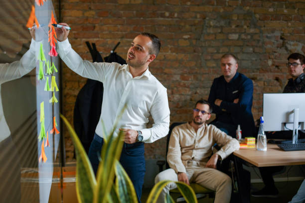Placing the adhesive note on a whiteboard. stock photo