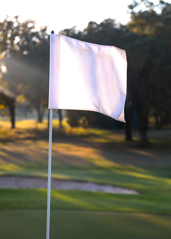 A plain white flag on a unrecognisable golf course in South Africa.
