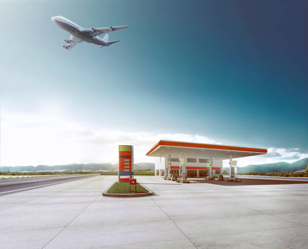 plane flying over gas station stock photo