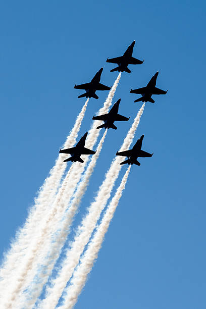 Planes silhouetted against dark blue sky stock photo